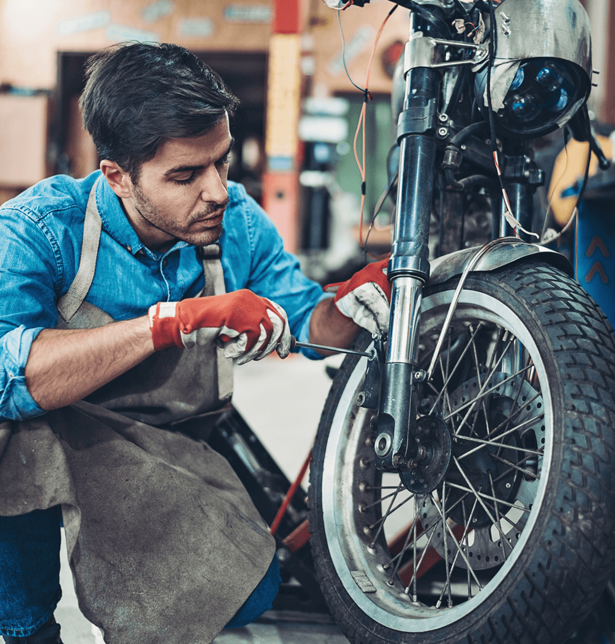Technician inspecting motorcycle tire.