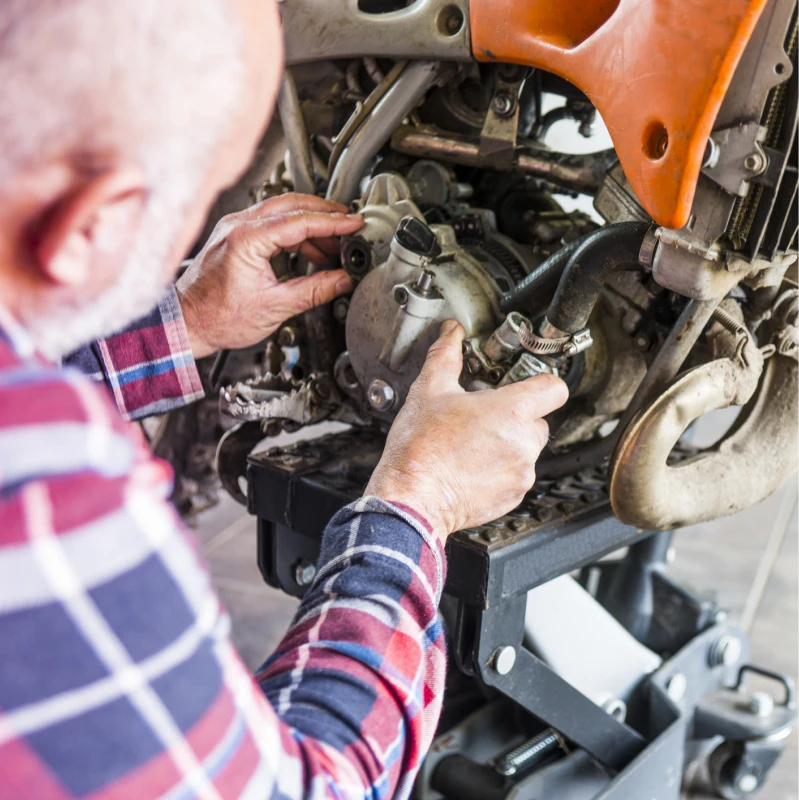 Mechanic repairing motorcycle engine